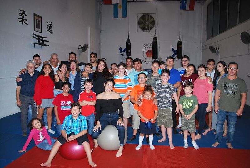 A big group of families, kids and teens together in the dojo.